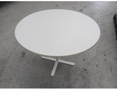 White round pedestal table featuring a clean, mini...