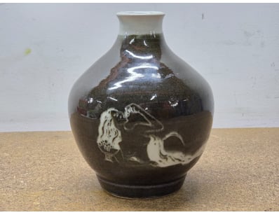 Striking ceramic vase featuring a bulbous, rounded...