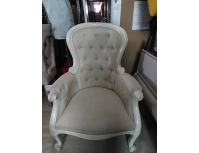 Elegant Victorian-style armchair featuring a white...