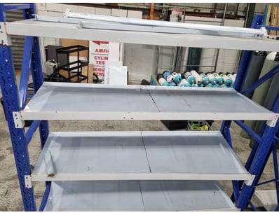 Industrial-grade steel shelving unit featuring blu...
