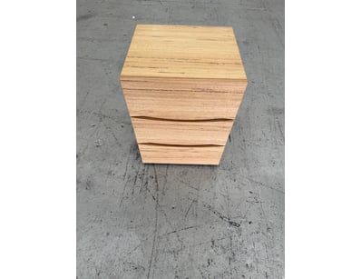 Modern timber bedside chest featuring three spacio...