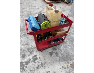 Three-tier red metal utility cart on wheels contai...