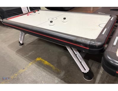 Air hockey table featuring a sleek black and red f...