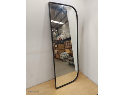 Modern black-framed arched floor mirror featuring ...