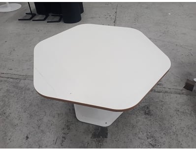 Modern pedestal dining table featuring a white lam...
