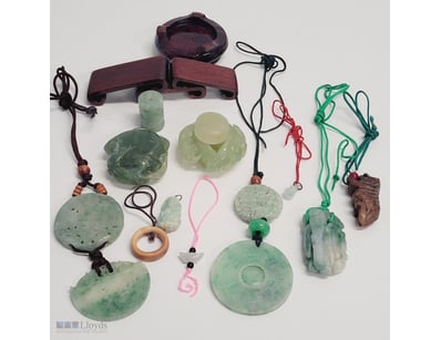 COLLECTION OF JADE PENDANTS AND WOODEN DISPLAY STA...