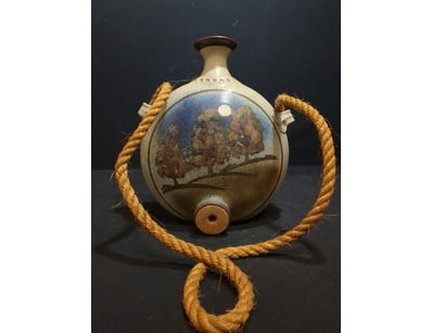 A charming ceramic vessel featuring a spherical bo...