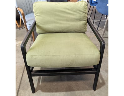 Modern lounge chair upholstered in soft sage green...