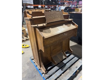Vintage wooden pump organ featuring oak constructi...
