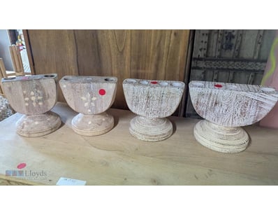 Set of four wooden pedestal candle holder featurin...