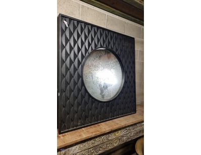 Contemporary wall mirror featuring a circular conv...