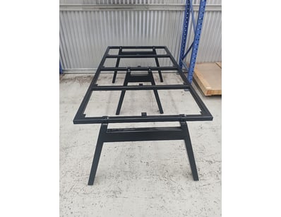 Modern dining table featuring a black powder-coate...
