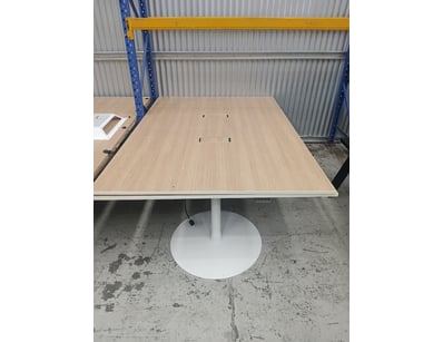 Modern round pedestal dining table featuring a lig...