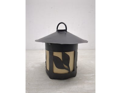 Decorative metal lantern featuring a cylindrical b...