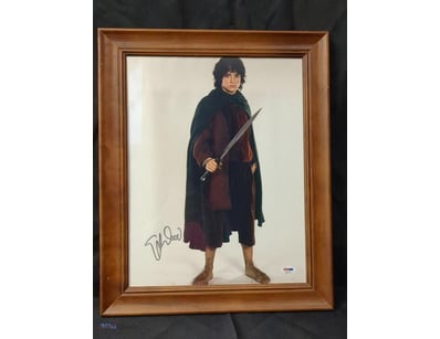 A FRAMED, AUTOGRAPHED PHOTOGRAPH OF ELIJAH WOOD AS...