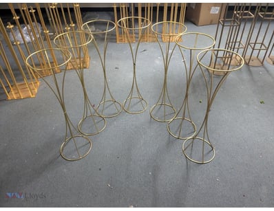 Lot of gold-toned metal plant stands featuring ele...