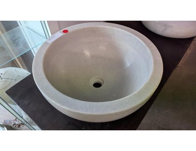 Elegant natural stone sink featuring a smooth, pol...