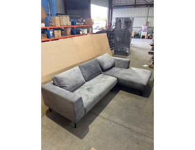 Modern grey upholstered sectional sofa featuring a...