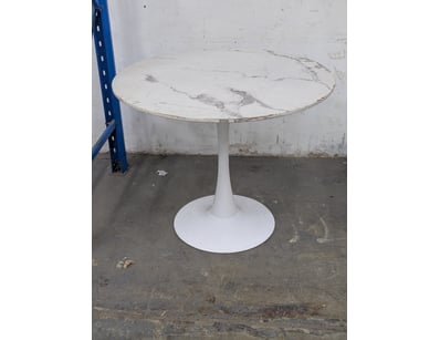 Modern pedestal dining table featuring a white mar...