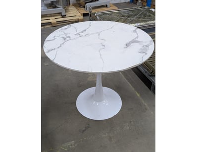 Modern pedestal dining table featuring a white mar...
