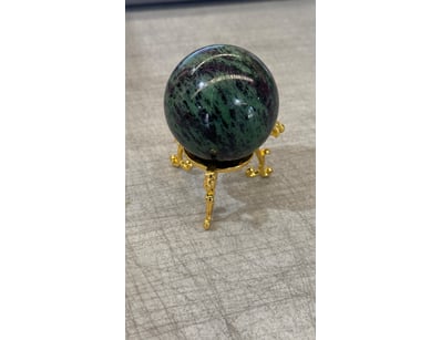 Polished sphere ornament featuring deep green and ...