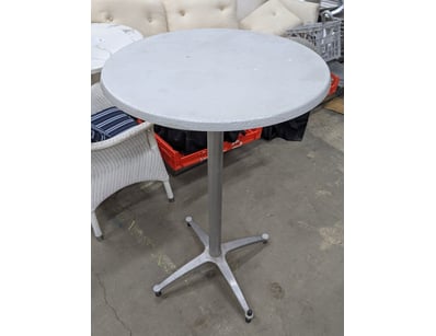 White round pedestal table featuring a textured co...