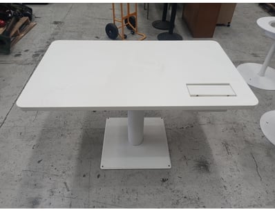 Modern white pedestal dining table featuring a rou...