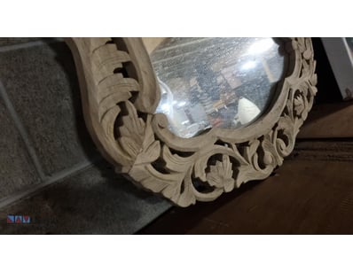 Ornate carved wooden mirror featuring an elaborate...