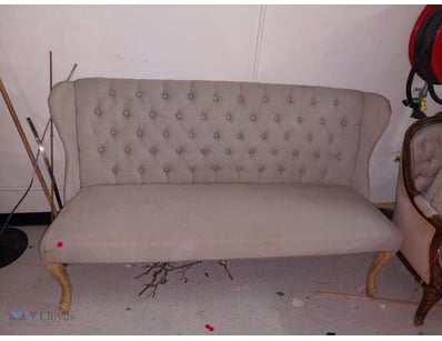 Elegant upholstered settee featuring button-tufted...