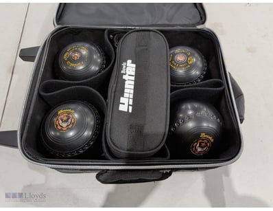 Professional lawn bowls set featuring four black b...