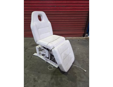 Electric treatment chair with white upholstered se...