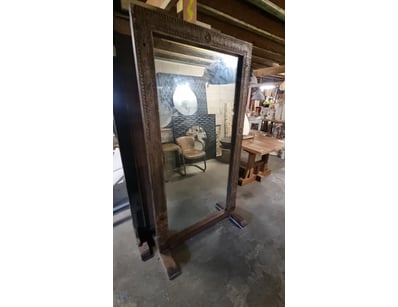 Ornate standing mirror featuring an elaborate carv...