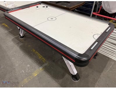 Air hockey table featuring a sleek black and red f...