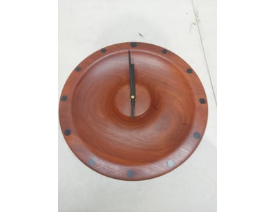 Handcrafted wooden wall clock featuring a round fa...