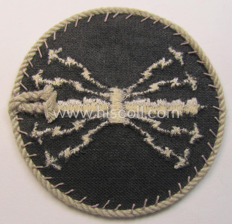 Attractive - and hardly used! - example of a WH (Luftwaffe) machine-embroidered, trade- ie. special-career-patch (ie. 'Tätigkeitsabzeichen') having a silverish-grey-toned 'Kordel' attached as was intended for: 'LW-Funk-Unteroffiziere'