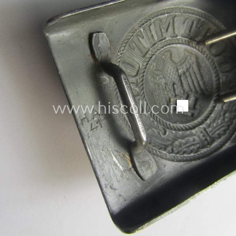 WH (Heeres) 'standard-pattern', field-grey-toned- and steel-based belt-buckle being a maker- (ie. 'H. Arld - Nuernberg'-) marked- and/or: '1941'-dated example that comes mounted onto its leather-based tab