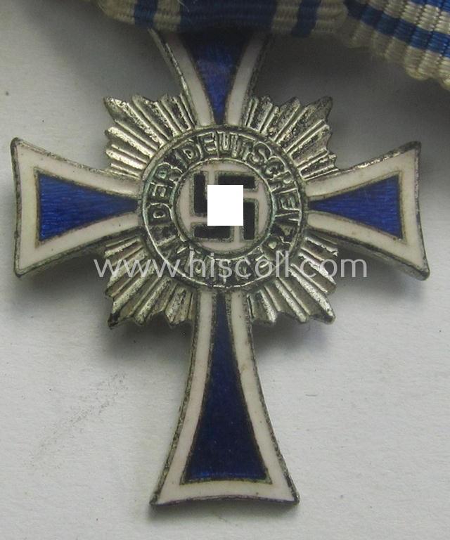Miniature of an: 'Ehrenkreuz der deutschen Mutter - zweite Stufe' (or: silver-class mothers'-cross) being a non-maker-marked example that comes in an overall nice- (albeit moderately worn- ie. used-), condition