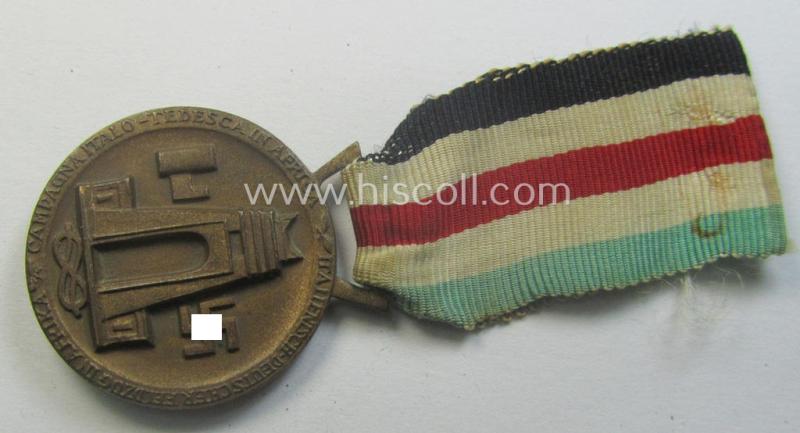 Golden-bronze-coloured example of a: 'Deutsch-Italienische Feldzugsmedaille' (or: German-Italian campaign-medal) that comes mounted onto its (regular-sized) piece of original (and minimally faded- ie. stained!) ribbon