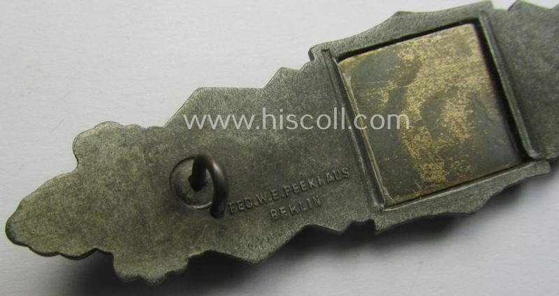 'Nahkampfspange in Bronze' (or: bronze-class close-combat clasp ie. CCC) being a maker- (ie. 'FLL'-) marked- and minimally converse-shaped so-called: '3rd pattern'-specimen as was produced by the maker- (ie. 'Hersteller') 'Friedrich Linden'