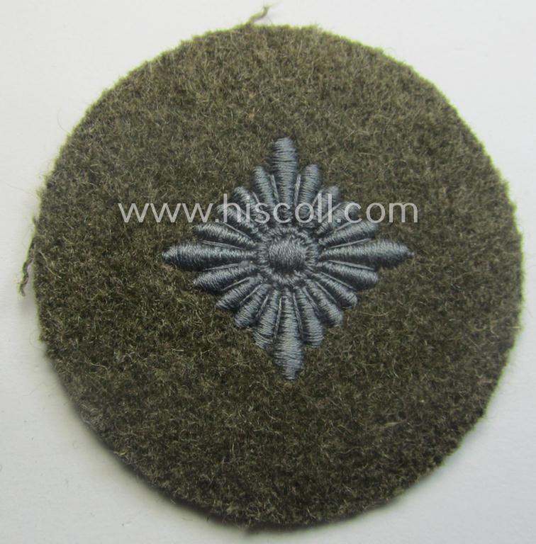 WH (Heeres) 'standard-type'- and early-pattern, tropical-style rank-insignia (ie. roundel), as executed in bluish-grey coloured linnen on a brownish-green background: 'Oberschütze'