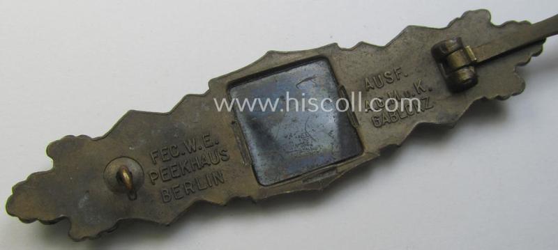 'Nahkampfspange in Bronze' (or: bronze-class close-combat clasp ie. CCC) being a maker- (ie. 'A.G.M.u.K.'-) marked- and/or minimal converse-shaped specimen having its period-attached (bluish-toned and steel-based) 'back-plate' in place