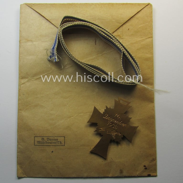 'Ehrenkreuz der deutschen Mutter - dritte Stufe' (or: bronze-class mothers'-cross) that came together with its long-sized ribbon and that came stored in its period pouch by the maker: 'G. Danner - Mühlhausen/Th.'