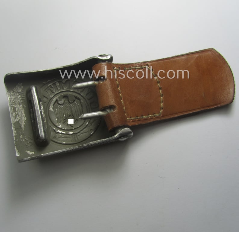 WH (Heeres) 'standard-pattern', field-grey-toned- and aluminium-based belt-buckle being a maker- (ie. 'Steinhauer & Lück'-) marked- and/or: '1939'-dated example that comes mounted onto its leather-based tab