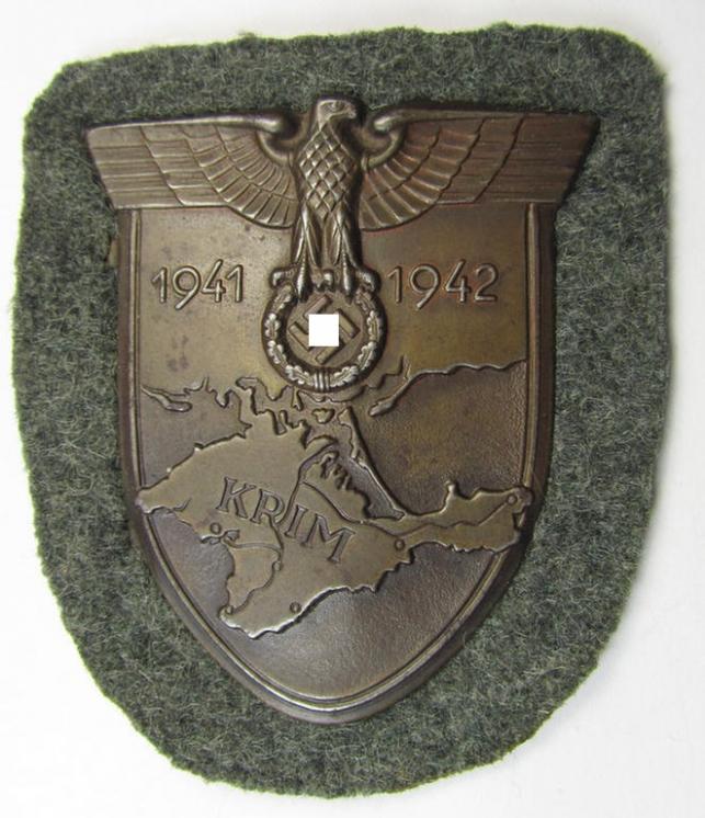 Attractive, WH (Heeres ie. Waffen-SS) 'Krim'-campaign-shield that comes mounted onto its original, field-grey-coloured 'backing' and that comes in a moderately used- and/or tunic-removed, condition