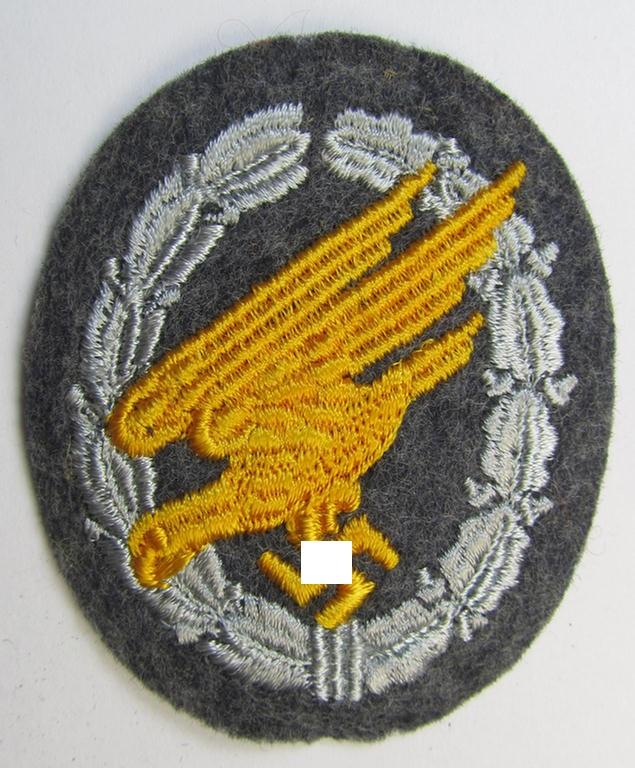 Attractive, WH (Luftwaffe) 'Fallschirmschützen-Abzeichen in Stoff' (or: cloth-based paratroopers'-jump-badge) being nicely machine-embroidered specimen that come in a never used- ie. 'virtually mint-/unissued', condition