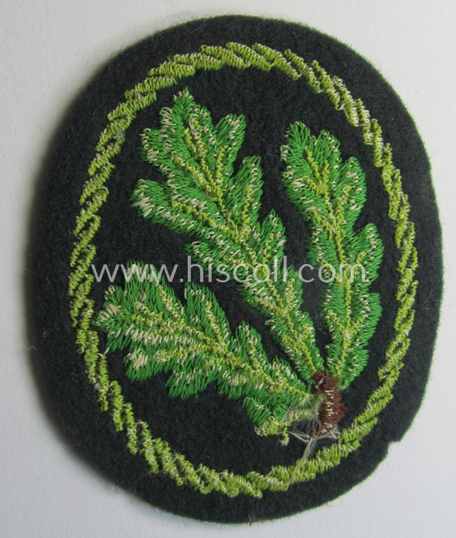 Attractive example of a WH (Heeres) so-called: 'Jäger'-armbadge being a neatly machine-embroidered- and/or multi-coloured version as was executed on darker-green-coloured wool