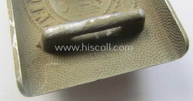 WH (Heeres) 'standard-pattern', field-grey-toned- and aluminium-based belt-buckle being a maker- (ie. 'Hermann Knoller - Pforzheim'-) marked- and/or: '1939'-dated example that comes mounted onto its leather-based tab