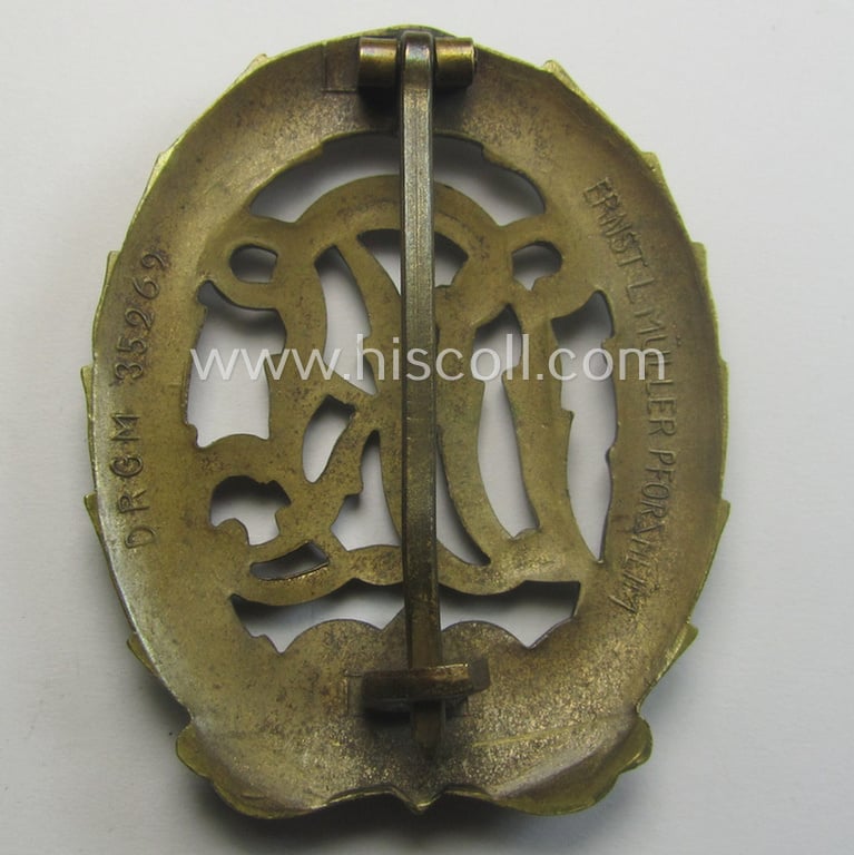 'Reichssportabzeichen DRL in Bronze' (or: bronze class DRL sports'-badge) being a maker- (ie. 'Ernst L. Müller'-) marked and that comes with its accompanying miniature