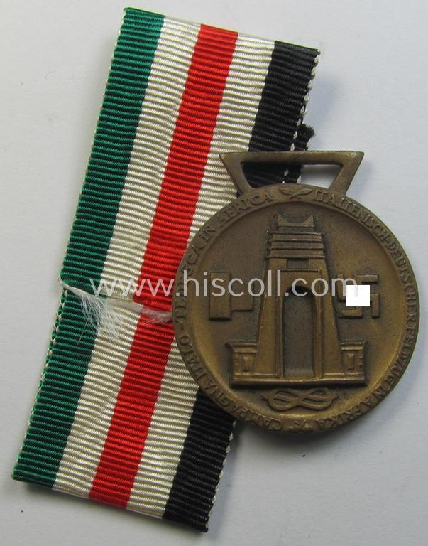 Superb, golden-bronze-coloured- (and I deem 'Buntmetall'-based-) example of a: 'Deutsch-Italienische Feldzugsmedaille' (or: German-Italian campaign medal) that came together with its (regular-sized) piece of original ribbon
