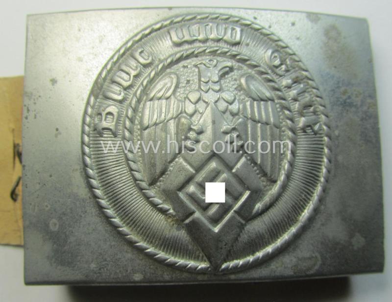 HJ ('Hitlerjugend'), zinc-based belt-buckle being a 'virtually mint' and/or non-maker-marked example having a seldomly seen 'cranked-catch'-set-up and that comes with its period 'RzM'-etiket still attached